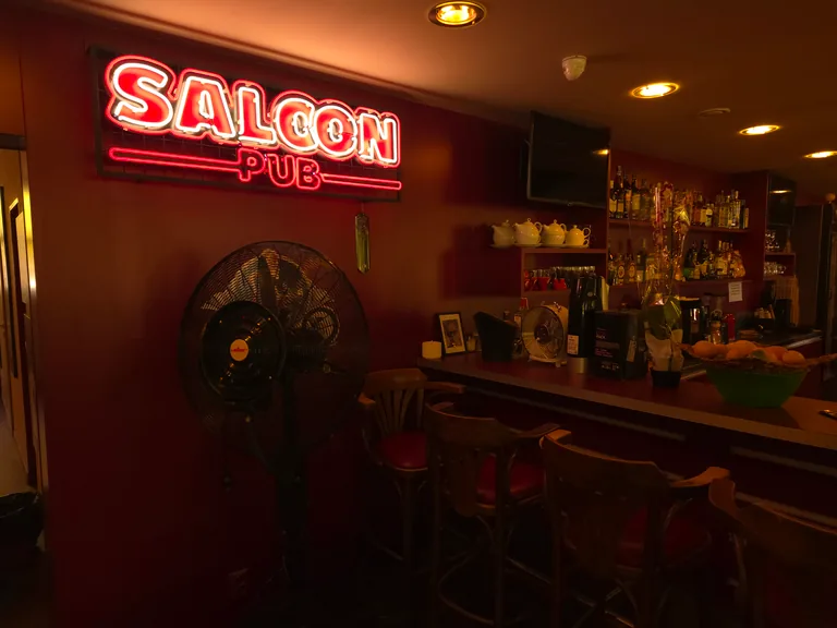 Zářící nápis Saloon nad vstupem do hlavního sálu